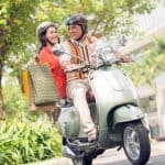 Midaldrende par på scooter med indkøbsposer